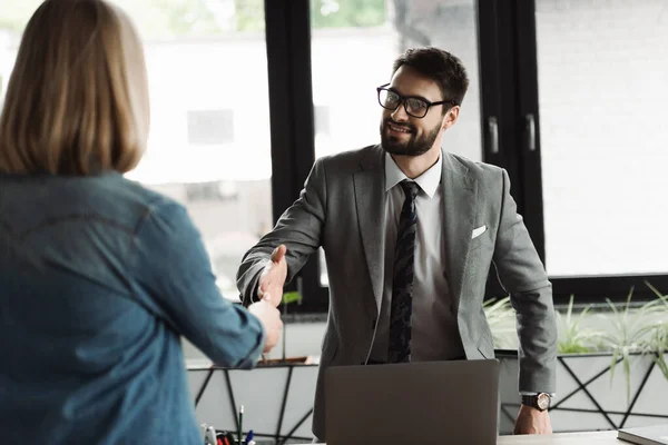 Empresário apertando a mão de candidato a emprego desfocado durante entrevista no escritório — Fotografia de Stock