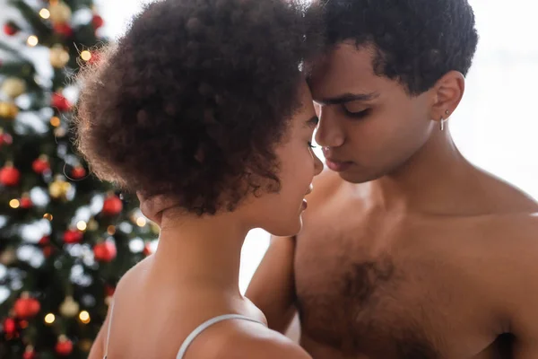 Jeune et sexy afro-américain homme debout près de frisé brunette copine à la maison — Photo de stock