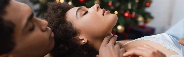 Vue latérale d'un homme afro-américain flou touchant le cou d'une jeune copine sexy, bannière — Photo de stock