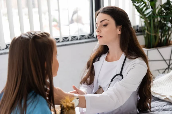Arzt in weißem Mantel kontrolliert Hals von Kind auf Krankenhausstation — Stockfoto