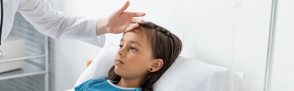 Médico comprobando la temperatura del niño en la cama en el hospital, pancarta - foto de stock
