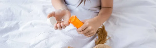 Visão de alto ângulo da criança segurando pílulas na cama no hospital, banner — Fotografia de Stock