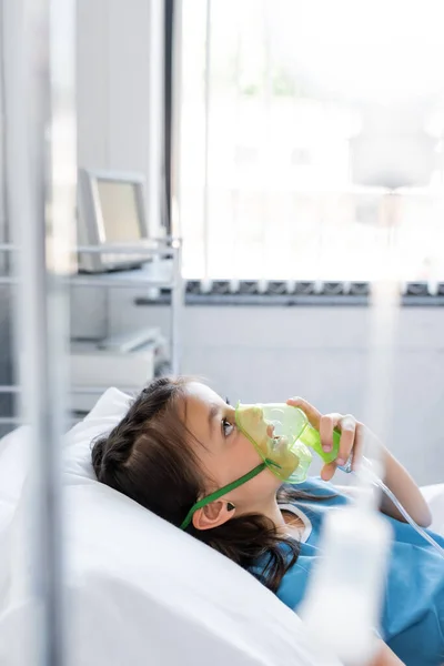 Kind mit Sauerstoffmaske liegt auf Krankenhausstation im Bett — Stockfoto
