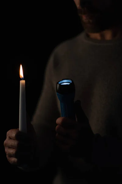 Abgeschnittene Ansicht des Mannes mit Taschenlampe und brennender Kerze isoliert auf schwarz — Stockfoto