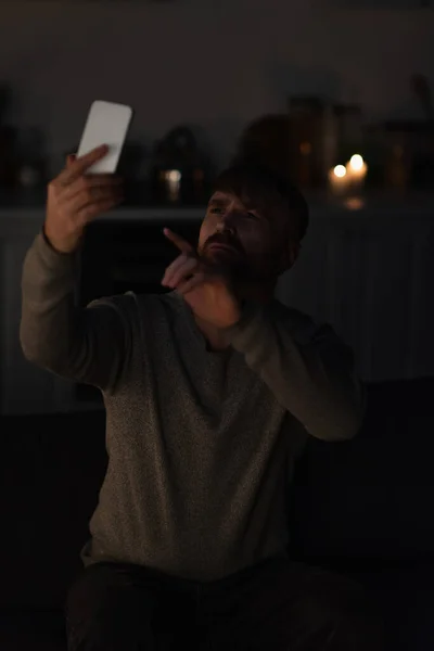 Homme pointant vers le téléphone portable tout en attrapant le signal perdu en raison de panne d'énergie — Photo de stock