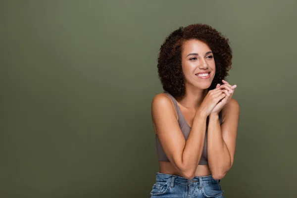 Cheerful african american woman in top looking away isolated on green — Stock Photo