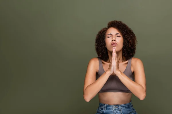 Riccio afroamericano donna con gli occhi chiusi pregando isolato su verde — Foto stock