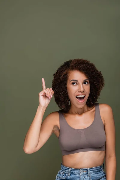 Excited african american woman in top having idea isolated on green — Stock Photo