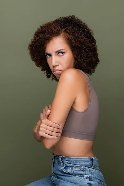 Embarrassed african american woman in top crossing arms isolated on green — Stock Photo