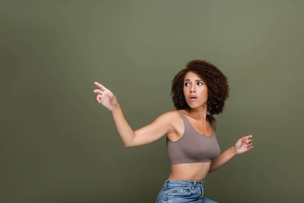 Preoccupata donna afro-americana in alto punta con dito isolato sul verde — Foto stock