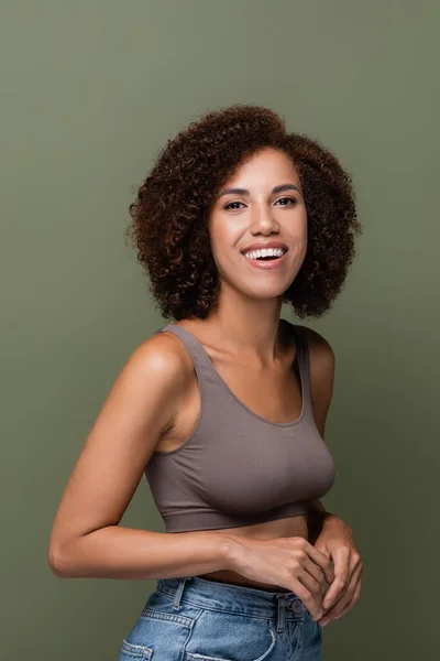 Porträt einer lockigen Afroamerikanerin in Top, die isoliert auf Grün in die Kamera blickt — Stockfoto