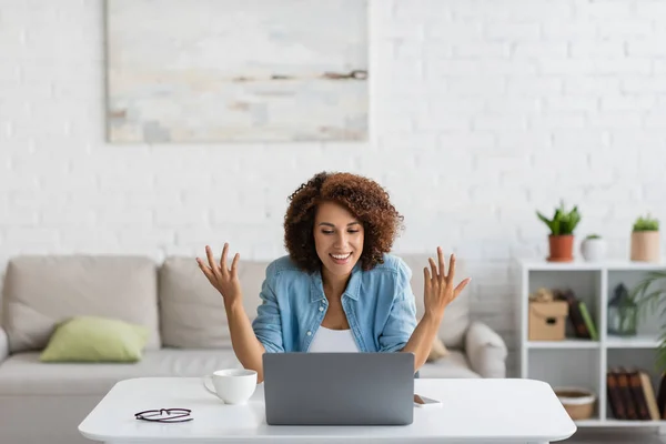 Happy african american freelancer gesturing during video call on laptop — Stock Photo