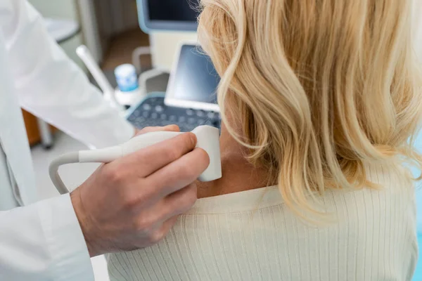 Vue recadrée du médecin examinant le système lymphatique de la femme blonde avec échographie — Photo de stock