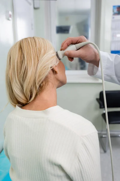Vista posteriore della donna bionda vicino al medico che fa diagnosi neurologiche della testa con ultrasuoni — Foto stock