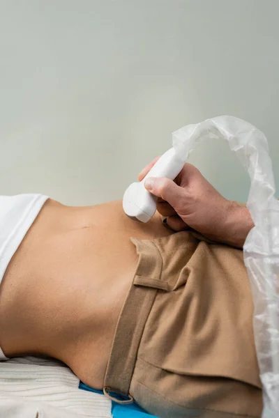 Visão parcial do médico fazendo ultra-som renal da mulher no hospital — Fotografia de Stock