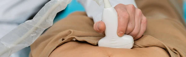 Cropped view of doctor doing kidneys ultrasound to woman in hospital, banner — Stock Photo