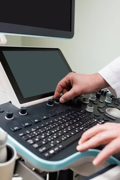 Vue partielle du médecin ajustant la machine ultrasonore moderne dans la clinique — Photo de stock