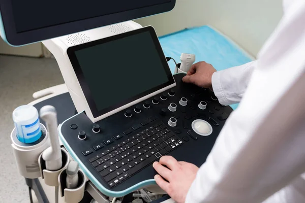 Hochwinkelaufnahme eines modernen Ultraschallgeräts in der Nähe eines zugeschnittenen Arztes — Stockfoto