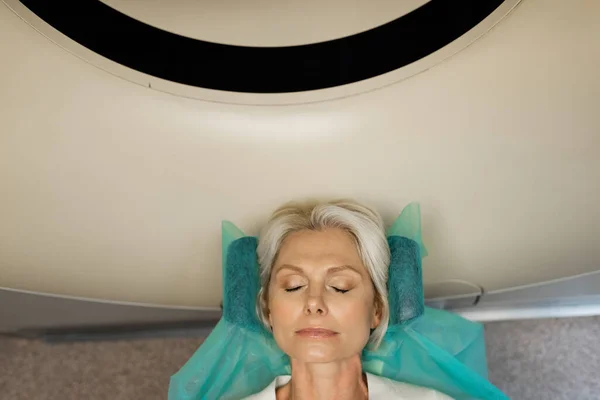 Top view of blonde woman making diagnostics on computed tomography scanner in clinic — Stock Photo