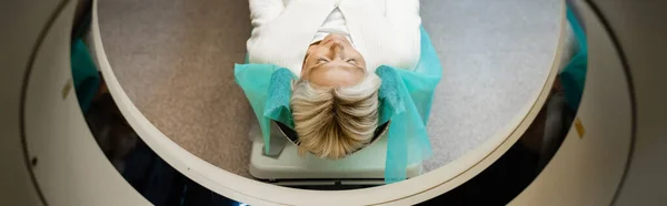 Hochwinkelaufnahme einer Frau mit geschlossenen Augen bei der Diagnostik auf dem CT-Scanner, Banner — Stockfoto