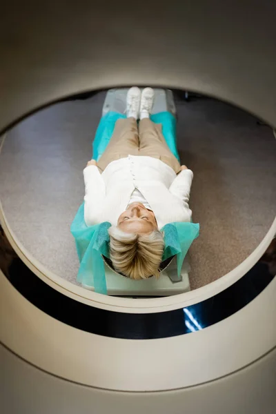 Ganzkörperansicht einer Frau mittleren Alters, die während der Untersuchung auf dem Scanner in der Klinik liegt — Stockfoto