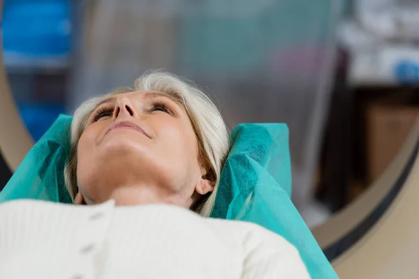 Mature woman lying during examination on computed tomography machine — Stock Photo