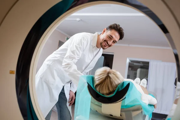 Radiologista sorrindo para a mulher durante tomografia computadorizada no hospital — Fotografia de Stock