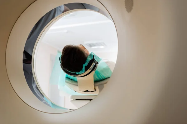 Брюнетка мужчина во время процедуры сканирования в компьютерной томографии машины — стоковое фото