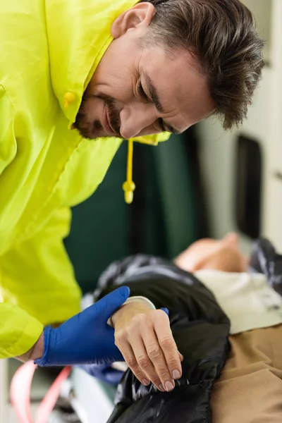 Impulso di controllo paramedico focalizzato della donna offuscata nel veicolo di emergenza — Foto stock