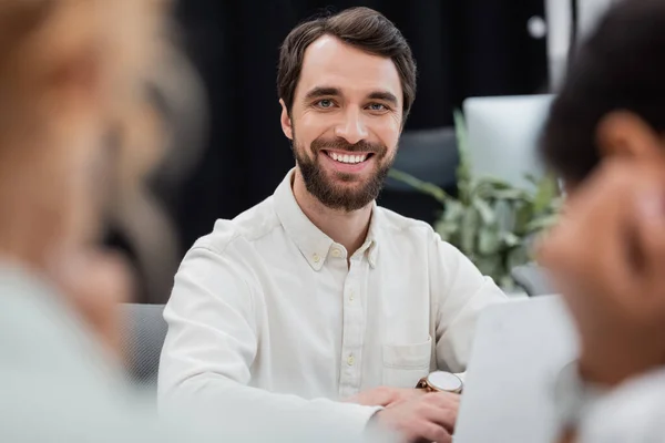 Bearded businessman looking at camera in office on blurred foreground — Stock Photo