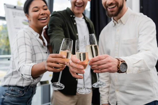 Розмиті багатонаціональні бізнесмени смердять шампанське під час корпоративної вечірки в офісі — стокове фото