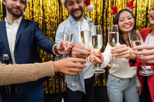 Размытые мультиэтнические бизнесмены, держащие шампанское во время празднования Нового года в офисе — стоковое фото
