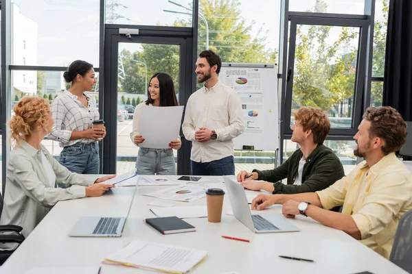 Multiethnische Geschäftsleute bei Vorträgen und Kaffeegesprächen während eines Treffens im Büro — Stockfoto