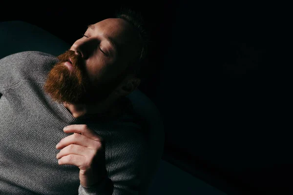 Стильная модель с бородой, изолированная на черном с освещением и тенью — стоковое фото