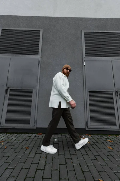 In voller Länge stylischer Hipster mit Beanie-Hut und Sonnenbrille auf der Straße — Stockfoto