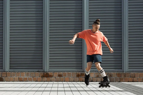 Patinador de patins em meias e shorts de joelho patinando na rua urbana — Fotografia de Stock