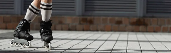 Обрезанный вид человека в коленных носках и роликовых коньках на открытом воздухе, баннер — стоковое фото