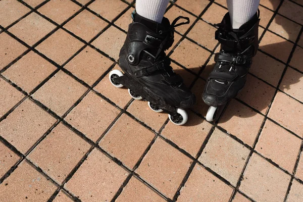 Вид зверху на людину в шкарпетках коліна і чорних роликах на відкритому повітрі — стокове фото
