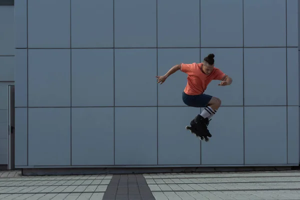 Молодой человек в повседневной одежде и ролики прыгают на улице — стоковое фото
