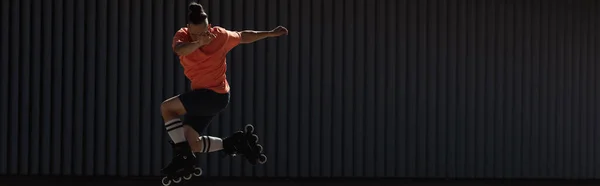 Людина в роликових лезах робить трюк на сонячному світлі на відкритому повітрі, банер — стокове фото