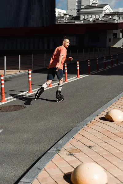 Vue latérale de l'homme en patins à roulettes sur la route dans la rue — Photo de stock