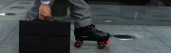 Обрезанный вид бизнесмена в роликовых коньках с портфелем на улице, баннер — стоковое фото