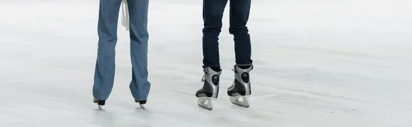 Cropped view of couple ice skating on rink, banner — Stock Photo