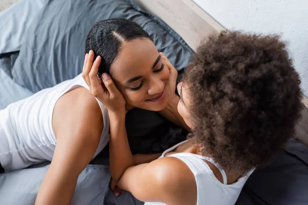 Blick von oben auf afrikanisch-amerikanische lesbische Frau auf glückliche Freundin im Schlafzimmer — Stockfoto