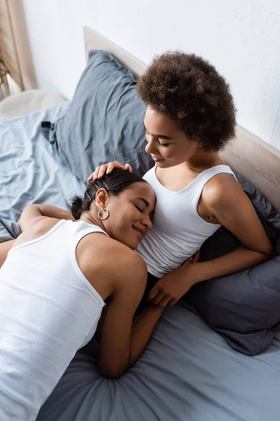 Top view of lesbian african american girlfriends resting on bed — Stock Photo
