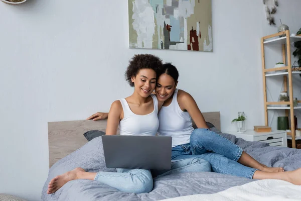 Africano casal lésbico americano olhando para laptop enquanto assiste filme no quarto — Fotografia de Stock