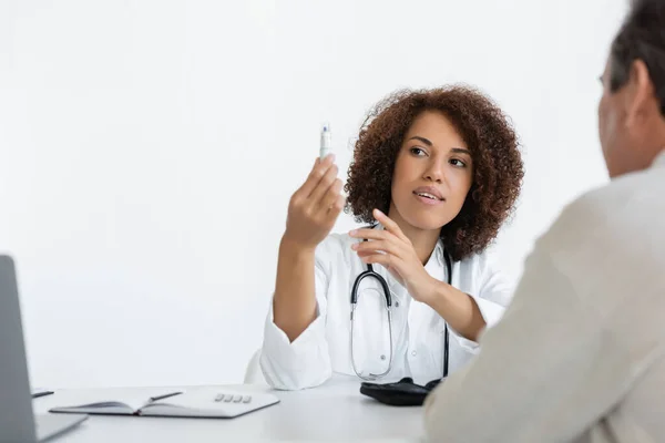 Afrikanisch-amerikanischer Arzt schaut sich Lanzettenstift in der Nähe von Patienten mittleren Alters mit Diabetes in der Klinik an — Stockfoto