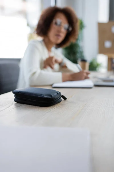 Diabetes kit near blurred african american businesswoman in office — Stock Photo