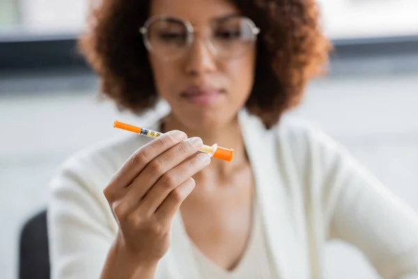 Femme d'affaires afro-américaine floue avec une seringue antidiabétique au bureau — Photo de stock
