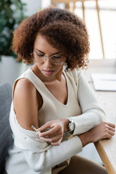 African american businesswoman with diabetes doing injection with insulin in office — Stock Photo